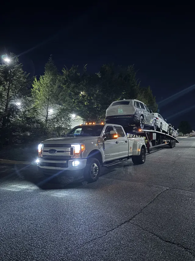 Loaded car hauler in a parking lot at night